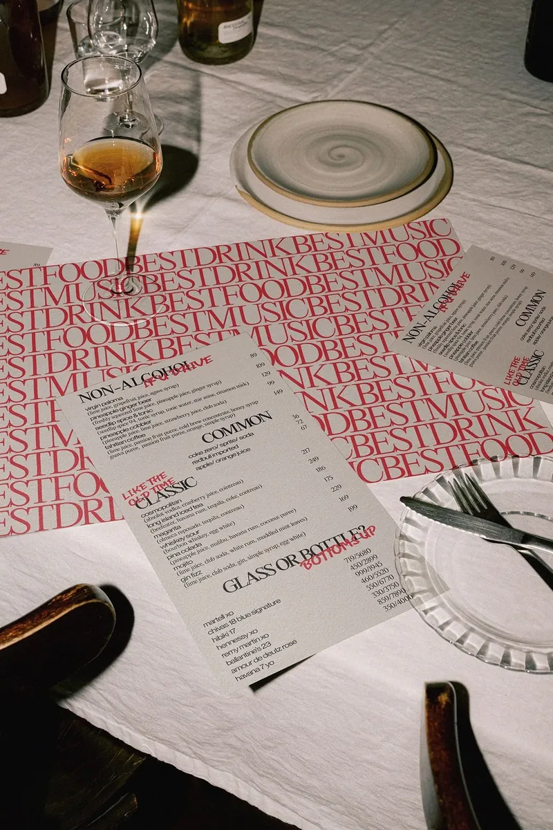 Gedeckter Tisch mit Weinglas, Tellern und Speisekarten