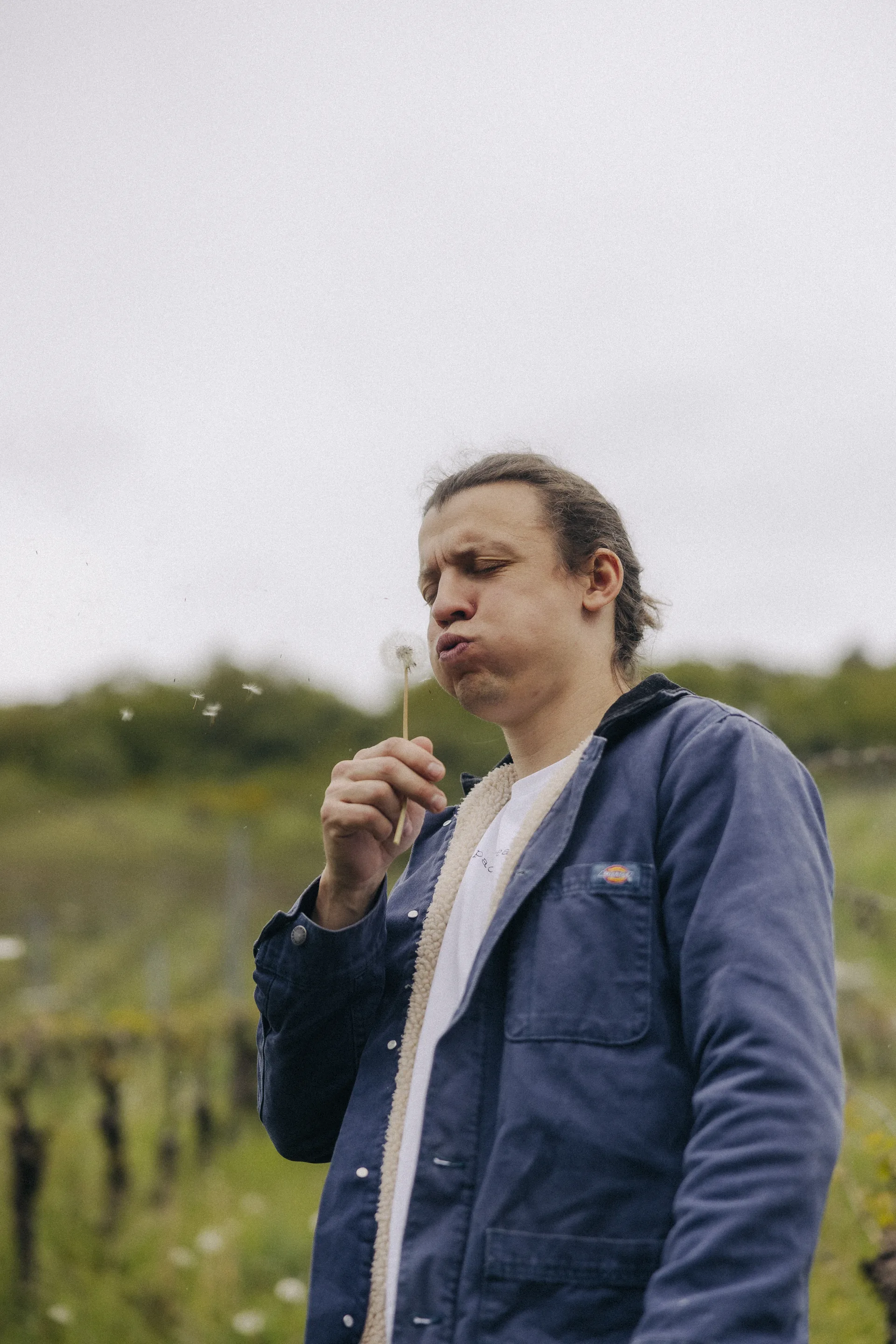 Jan-Philipp blowing a dandelion in the vineyard