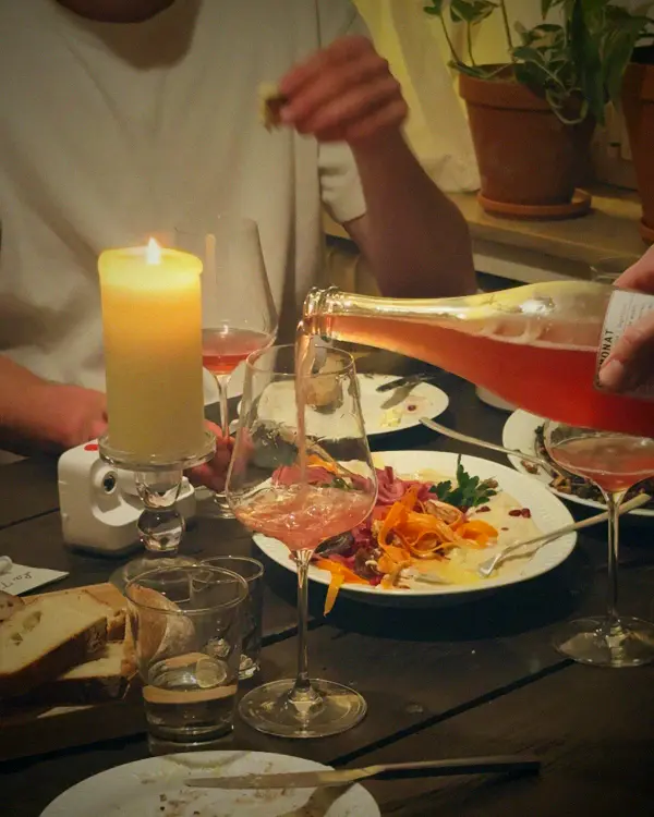 Rosé wird am gedeckten Tisch eingeschenkt