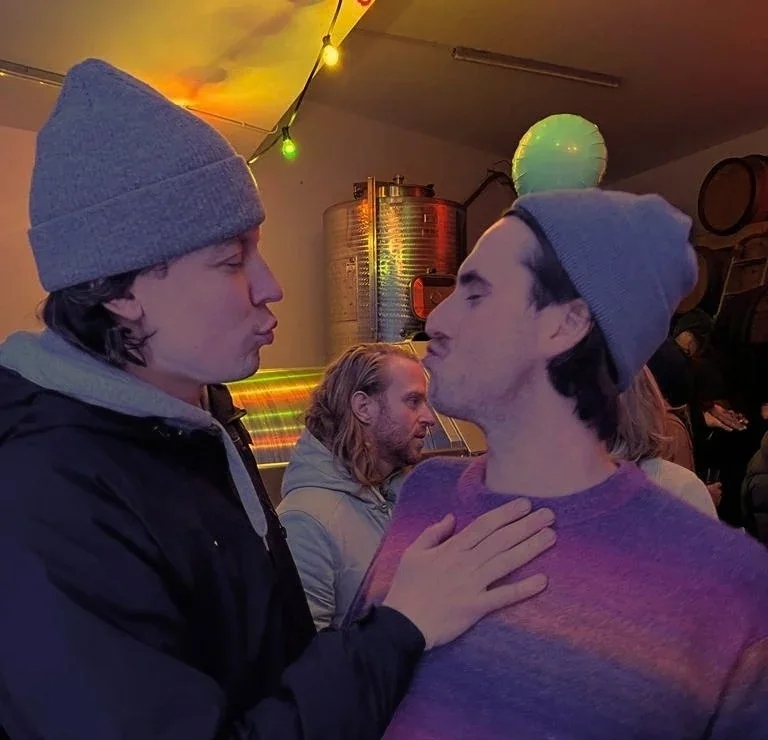 Ich links und Mats rechts, beide mit Mütze, die Lippen zum Spaßkuss gespitzt. Ole steht im Hintergrund zwischen den beiden.
